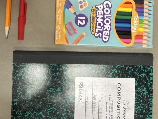 Útiles escolares: cuaderno, lápices, lapiceras, pegamento y tijeras sobre una superficie